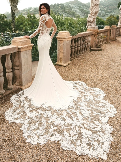 Enzoani Waverly wedding dress featuring a fitted mermaid silhouette, illusion lace bodice, high neckline, long lace sleeves, and dramatic lace train. Luxury designer bridal gown by Enzoani for modern brides seeking elegant, romantic, couture wedding dresse